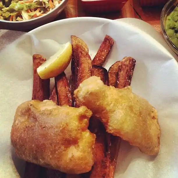 Fish and chips, tartar sauce, cole slaw, mushy peas, and a Newcastle.